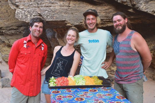 Smiling river guides next to dinner