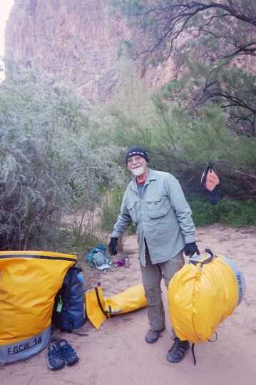 Person standing with a large dry bag.