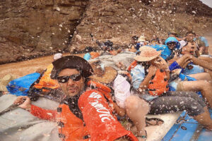 A selfie of people going through a rapid.