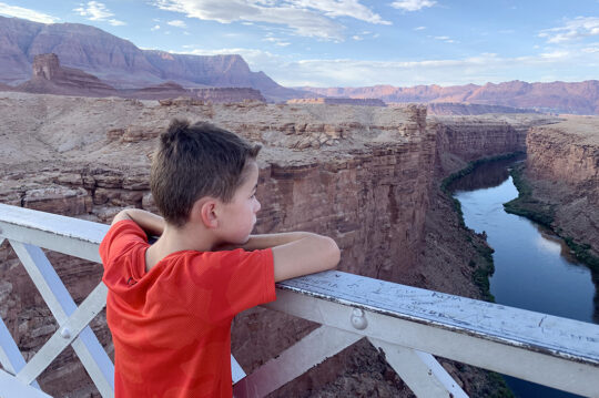 A child looking over the Colorado River on a bridge