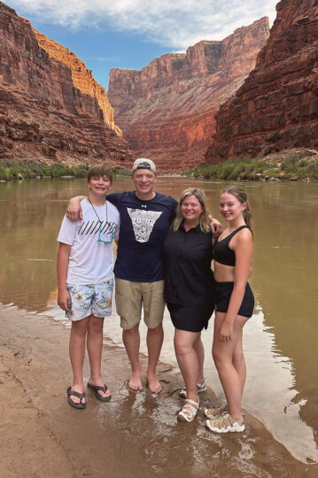 Mom, dad, son, and daughter posing with the Grand Canyon in the background.