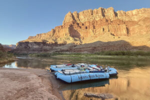 Motor boats with a Grand Canyon sunset behind. 