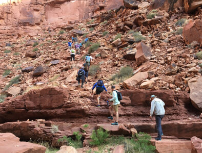 Guests hiking up rocky slope