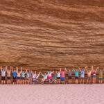 A long line of people holding their arms up in the air smiling