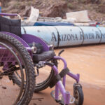 A wheelchair next to a Grand Canyon rafting motor boat