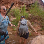 Blind person holding a cane smiling while on a hike in Grand Canyon