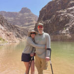A person with only one leg getting hugged by a woman along the Colorado River