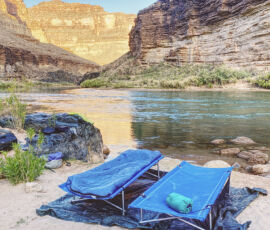 Two cots set up near the Colorado River.