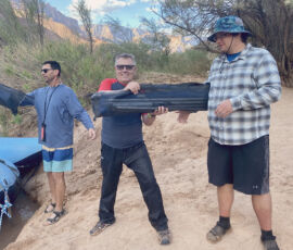 A person unloading cots from a boat.