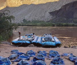 Dry bags laid out in front of a motor boat.